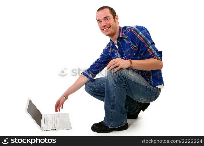 Attractive 20 something man with laptop on floor.