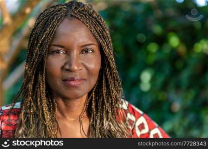Attractive African or African American middle aged woman, female in Africa, with braided hair in braids, wearing traditional clothes