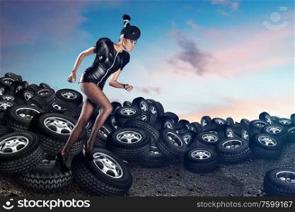 Attractive african woman running on tires on the blue sky