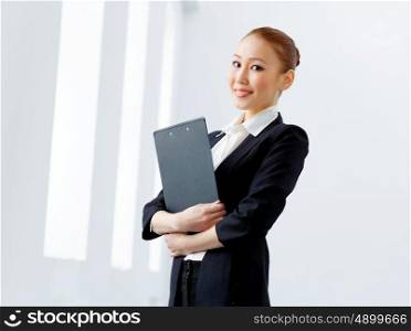 Attractive asian businesswoman in formal suit. Image of young asian businesswoman in formal suit holding folder