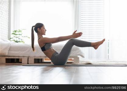 Attractive Asian indian woman practice yoga boat pose or Navasana pose to meditation in bedroom after wake up in the morning Feeling so comfortable and relax,Healthcare Concept