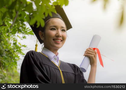 Attractive Beautiful Asian Graduated woman in cap and gown smile with certificated feeling so proud and happiness in success graduated day,Education Success Concept