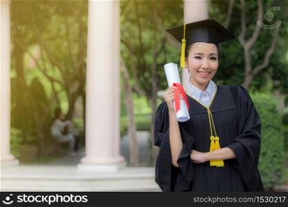 Attractive Beautiful Asian Graduated woman in cap and gown smile with certificated feeling so proud and happiness in success graduated day,Education Success Concept