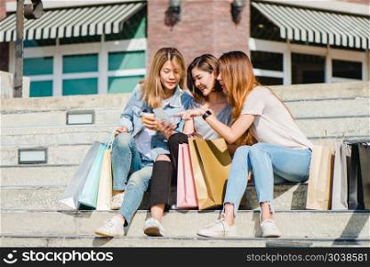 Attractive beautiful asian woman using a smartphone while shoppi. Attractive beautiful asian woman using a smartphone while shopping in the city. Happy young asian teenage at urban city while taking self portraits with her friends together with a smartphone.