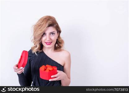 Attractive beautiful model woman holds heart shaped gift box.Valentine&rsquo;s Day concept in studio on a white background.