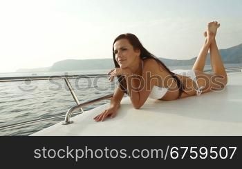 Attractive bikini woman sunbathing on luxury yacht