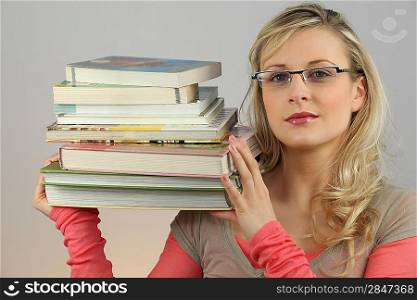 Attractive blond carrying pile of books