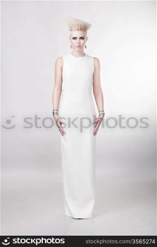 attractive blond woman in long white dress with creative hairstyle