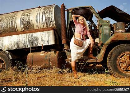 Attractive blond woman near the old car