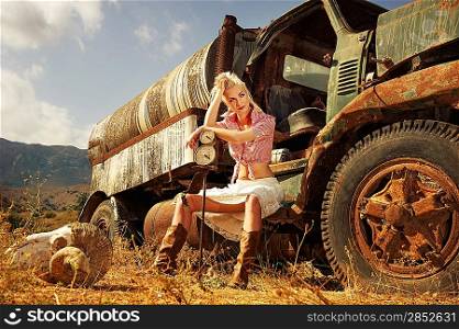 Attractive blond woman sitting in the old car
