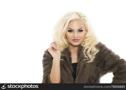 Attractive blond woman with lovely long wavy hair in an elegant winter jersey standing with her hand raised looking at the camera with a quiet smile, isolated on white with copyspace