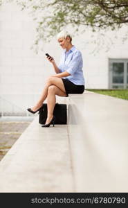Attractive blonde businesswoman is checking her phone
