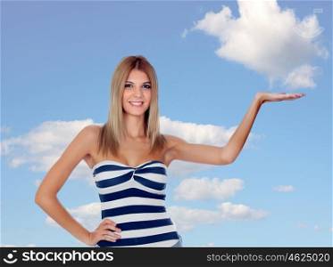 Attractive blonde girl with her hand extended and a blue sky of background