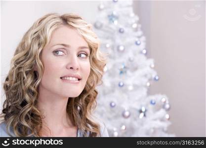 Attractive blonde in front of a christmas tree