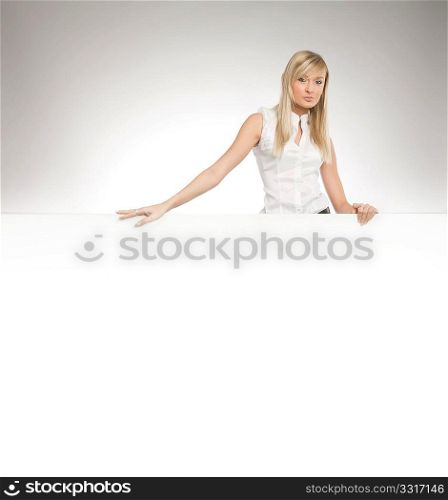 Attractive blonde secretary over white empty board, lots of copyspace