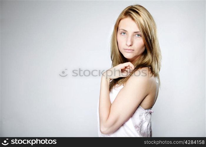 Attractive blonde woman with no make up gray background