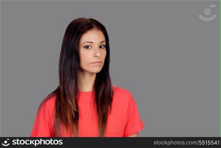 Attractive brunette girl dressed in red on a gray background