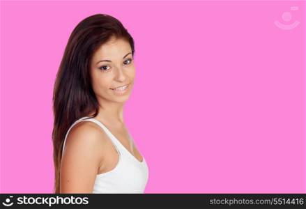 Attractive brunette girl dressed in white on a pink background