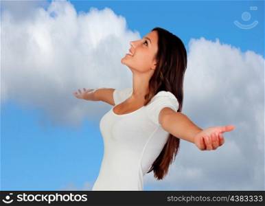 Attractive brunette girl with extended arms on a blue sky of background