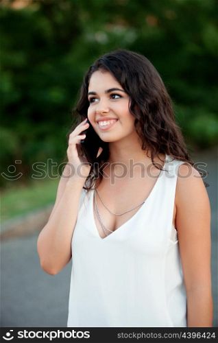 Attractive brunette girl with mobile on the park