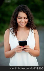 Attractive brunette girl with mobile on the park