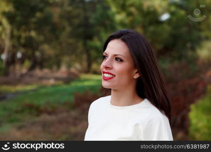 Attractive brunette girl with red lips in the forest