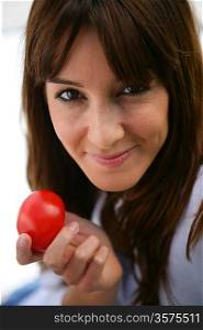Attractive brunette holding a tomato