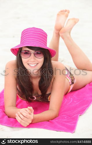 Attractive brunette laying on beach towel