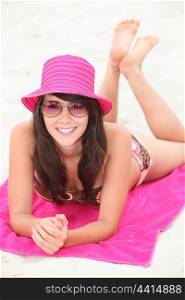 Attractive brunette laying on beach towel
