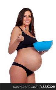 Attractive brunette pregnant in underwear eating salade isolated on a white background