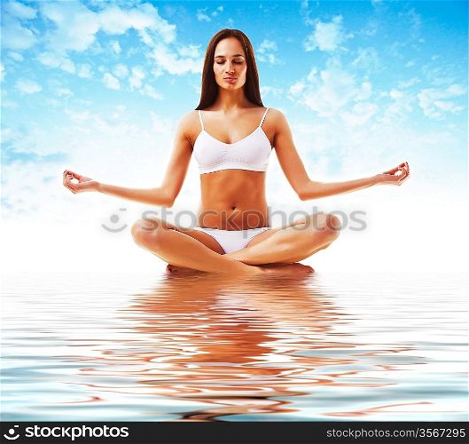 attractive brunette woman in yoga poseattractive brunette woman in yoga pose and sky