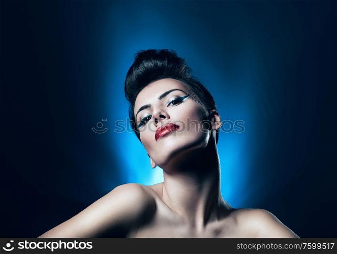attractive brunette woman with red lips in blue light