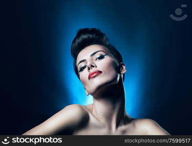 attractive brunette woman with red lips in blue light