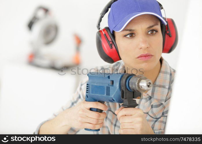 attractive builder woman with a drill in her hands