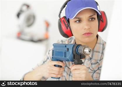 attractive builder woman with a drill in her hands