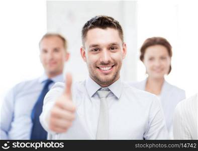 attractive businessman in office showign thumbs up