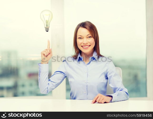 attractive businesswoman at office. business and office concept - smiling businesswoman pointing finger up in office