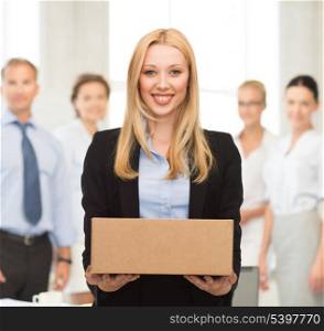 attractive businesswoman delivering cardboard box in office