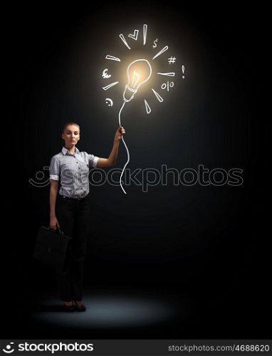 Attractive businesswoman. Image of attractive businesswoman against dark background and bulb