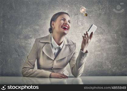 Attractive businesswoman in grunge style. Beautiful businesswoman with phone in hand sitting at table and laughs