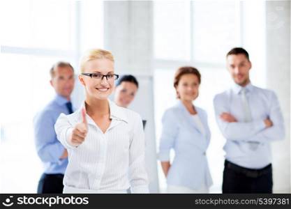 attractive businesswoman in office showign thumbs up