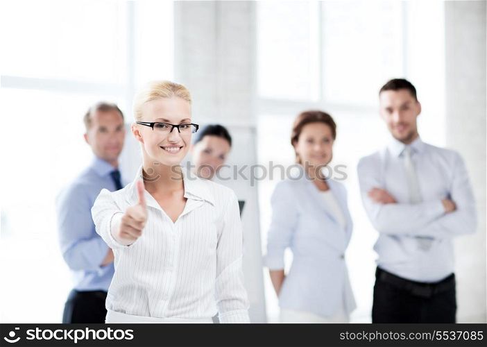 attractive businesswoman in office showign thumbs up