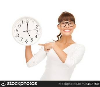 attractive businesswoman pointing her finger at wall clock