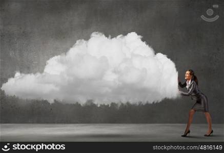 Attractive businesswoman pushing big cloud with effort. Computing concept