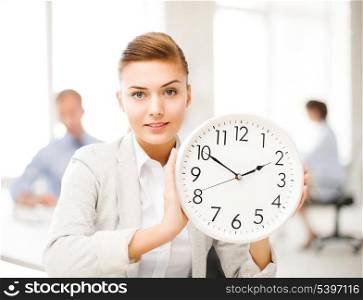 attractive businesswoman showing white clock in office