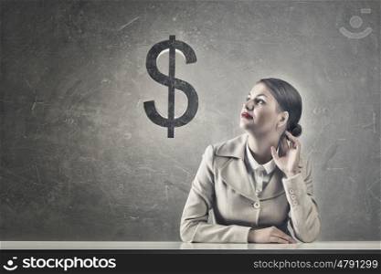 Attractive businesswoman sitting at table. Young businesswoman sitting at table and looking dreamily at dollar sign