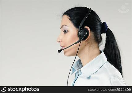 Attractive call center operator portrait. Sexy girl wearing headset standing on uniform background. One of a series.