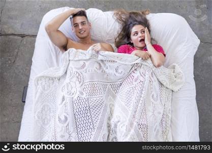Attractive Caucasian man and woman having fun in bedroom. Love and happiness concept