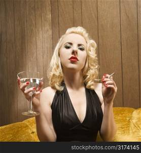 Attractive Caucasian woman holding a martini and cigarette.