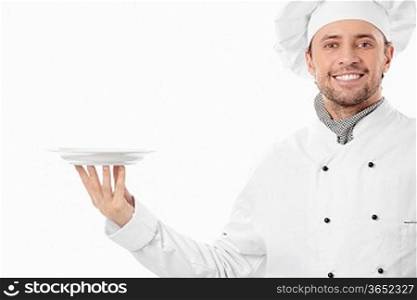 Attractive cook holding an empty plate on a white background